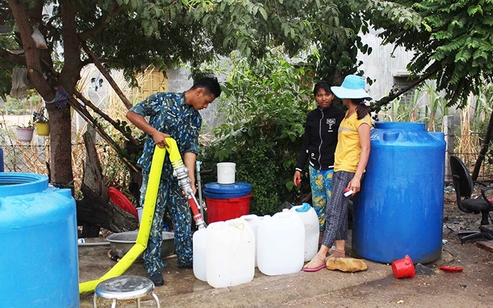 Cán bộ, chiến sĩ Trung đoàn Không quân 937 chở nước từ đồng bằng đến cấp phát cho đồng bào dân tộc Ra Glai, xã Phước Trung, huyện Bác Ái.