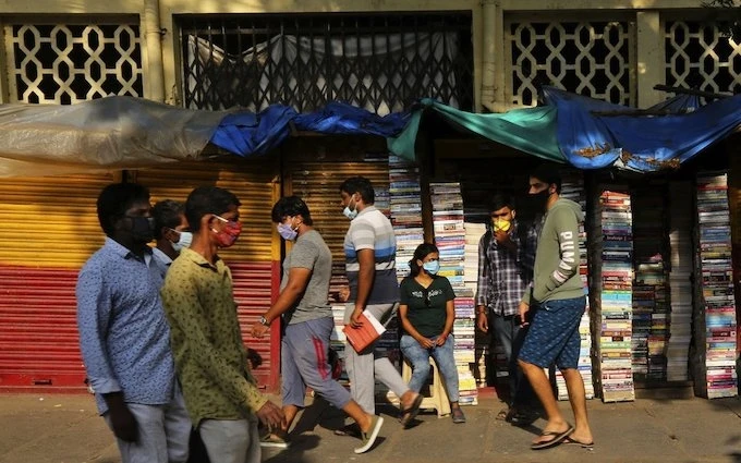 Người dân Ấn Độ đeo khẩu trang đi bộ qua một tiệm sách bên đường, ở Bengaluru, Ấn Độ, ngày 26-5-2020. (Ảnh: AP)