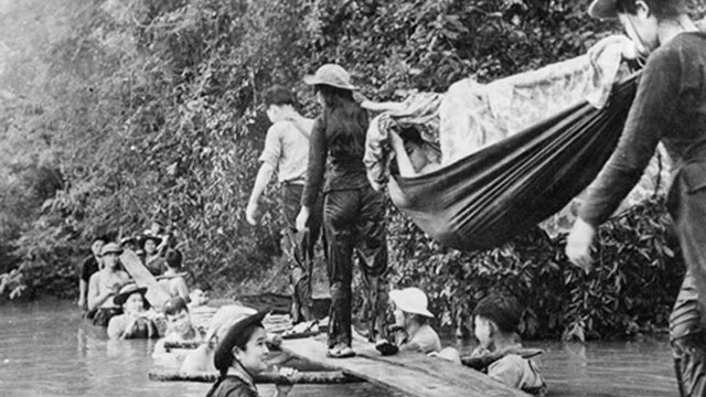Hình ảnh đẹp về Thanh niên xung phong lấy thân mình làm trụ cầu để đồng đội tải thương binh. (Ảnh tư liệu Bảo tàng Lịch sử Quốc gia Việt Nam) 
