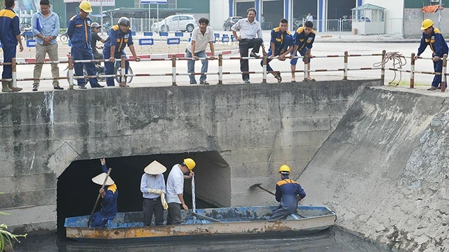 Kiểm tra mức độ ô nhiễm tại các cống thoát nước thải ở Hà Nội. Ảnh: LAM ANH