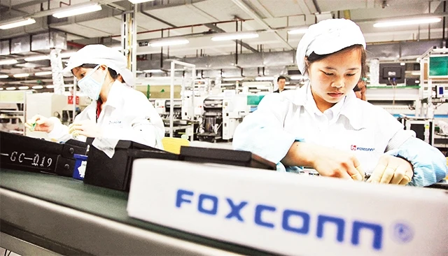 Công nhân Trung Quốc lắp ráp các linh kiện điện tử tại nhà máy của Foxconn - công ty chuyên cung cấp linh kiện cho Apple.