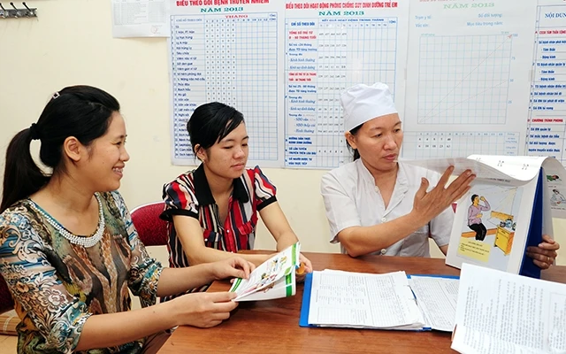 Cán bộ Trạm y tế xã Tân Trào, huyện Sơn Dương (Tuyên Quang) hướng dẫn người dân các biện pháp kế hoạch hóa gia đình. Ảnh: Hải Thanh