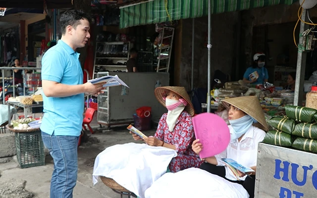 Cán bộ bảo hiểm xã hội đến chợ Kho Đỏ, phường Nguyễn Trãi (TP Hải Dương) tuyên truyền trực tiếp cho từng người dân. Ảnh: MẠNH MINH