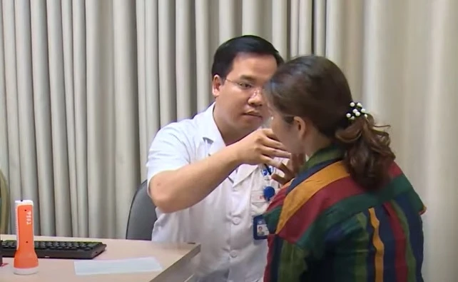 BS Nguyễn Tiến Thành đang khám cho một người bệnh bị cháy nắng gây bỏng rát da.