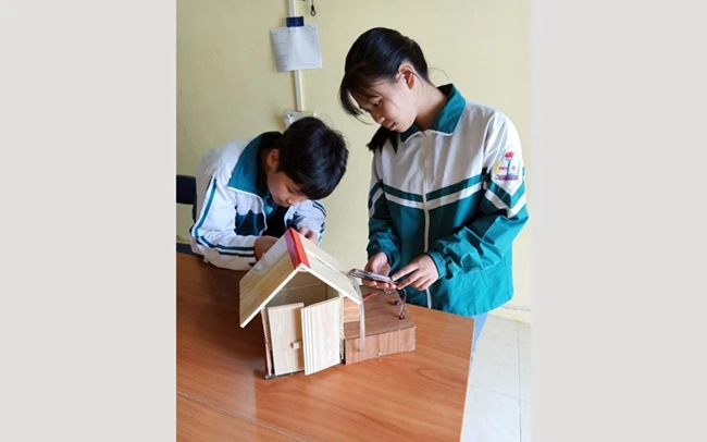 Học sinh Hồng Anh và Quỳnh Trang với mô hình “Ngôi nhà chữa cháy thông minh”.