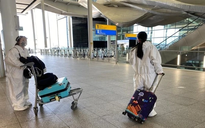 Hành khách mặc đồ bảo hộ khi tới sân bay Heathrow, London, ngày 22-5. (Ảnh: Reuters)