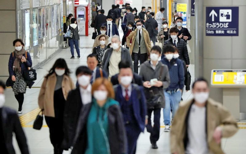 Người dân Nhật Bản đeo khẩu trang, di chuyển tại một nhà ga ở Tô-ki-ô. Ảnh ROI-TƠ