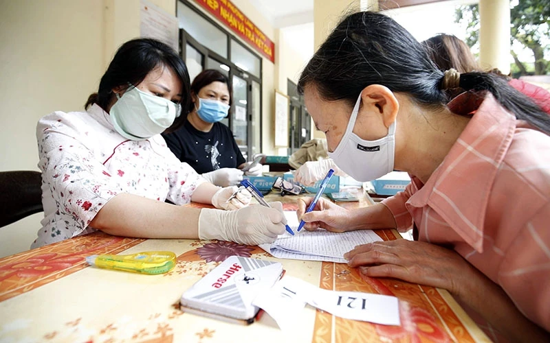 Người dân tại phường Láng Thượng, quận Ðống Ða (Hà Nội) nhận tiền hỗ trợ do dịch Covid-19. Ảnh: MINH HÀ