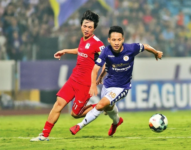 Pha tranh bóng giữa cầu thủ đội Hà Nội FC (áo tím) và đội Hoàng Anh Gia Lai. Ảnh: TRẦN ANH 