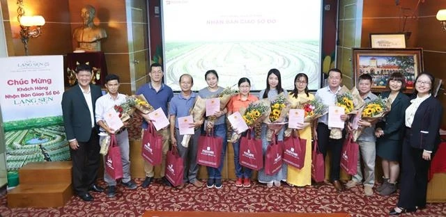 Đại diện chủ đầu tư trao giấy chứng nhận chủ quyền cho khách hàng.