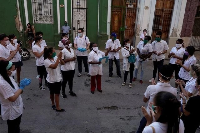 Các nhân viên y tế trao đổi trước khi kiểm tra cho các bệnh nhân có dấu hiệu mắc Covid-19 tại ngoại ô Havana (Ảnh: REUTERS)