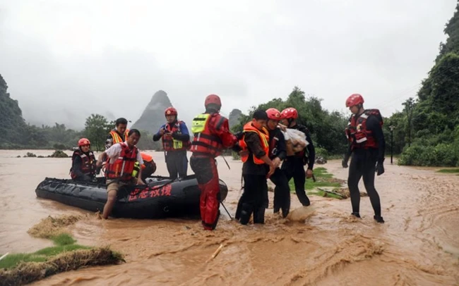 Lực lượng cứu hộ Trung Quốc sơ tán người dân ở vùng lũ. Ảnh GULF NEWS