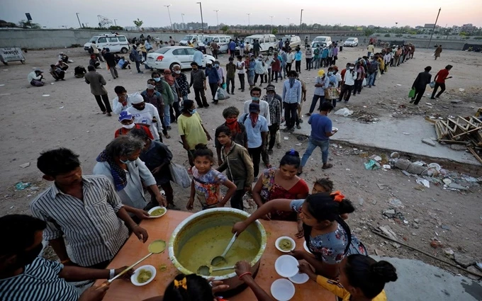 Người lao động di cư và người vô gia cư xếp hàng nhận thực phẩm miễn phí tại Ahmedabad, Ấn Độ, ngày 1-5, trong thời gian nước này ban bố lệnh phong tỏa để ngăn chặn Covid-19 lây lan. (Ảnh: Reuters)