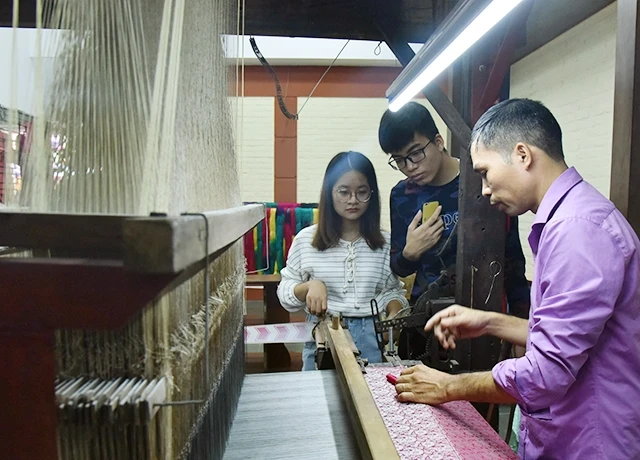 Du khách tham quan quy trình sản xuất lụa truyền thống tại làng lụa Vạn Phúc (Hà Đông). Ảnh: ĐĂNG ANH
