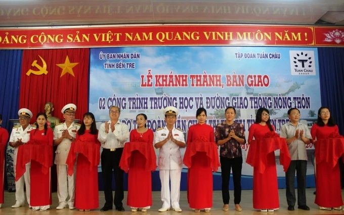 Đại diện chính quyền địa và nhà tài trợ cắt băng khánh thành các công trình trường học và đường giao thông nông thôn.