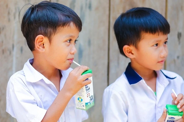 Các em học sinh huyện Đông Giang nhận những hộp sữa đầu tiên khi đến lớp theo chương trình Sữa học đường.