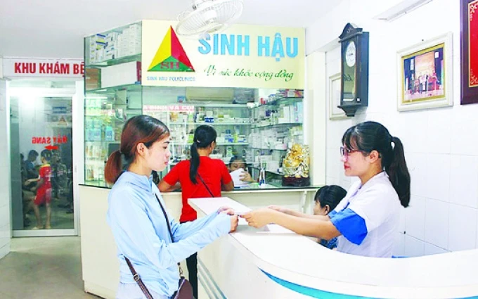 Nhân viên Phòng khám đa khoa Sinh Hậu (TP Vĩnh Yên, Vĩnh Phúc) hướng dẫn thủ tục khám bệnh BHYT cho người bệnh.