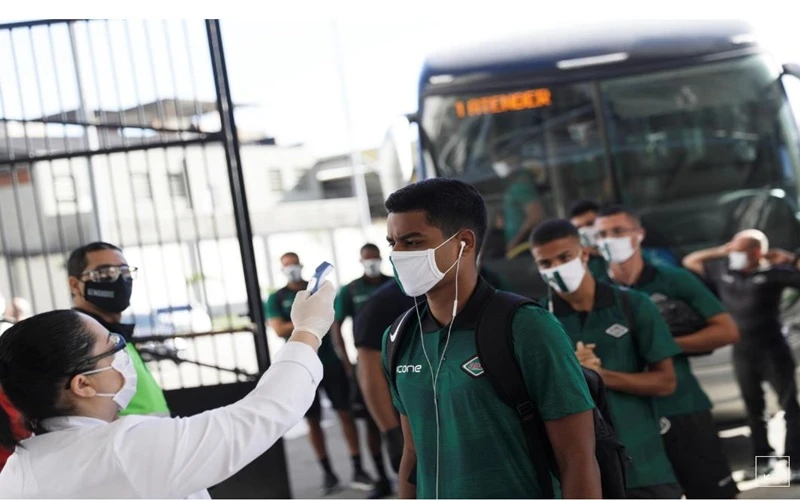 Nhân viên y tế kiểm tra thân nhiệt của thành viên các đội bóng trước giờ bóng lăn tại sân vận động Nilton Santos, ở Rio de Janeiro, Brazil, ngày 28-6. (Ảnh: Reuters)