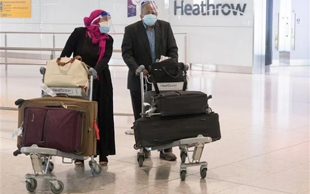 Hành khách đeo khẩu trang phòng lây nhiễm COVID-19 tại sân bay Heathrow ở London, Anh, ngày 8-6-2020. (Nguồn: THX/TTXVN)
