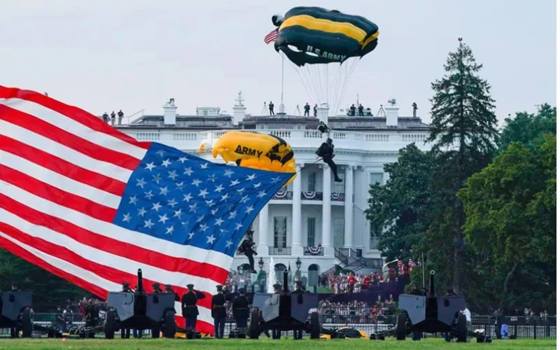 Mang theo quốc kỳ Mỹ, thành viên của đội nhảy dù đáp xuống công viên Ellipse của Nhà trắng trong sự kiện “Chào nước Mỹ” được tổ chức vào ngày 4-7. (Ảnh: Reuters)