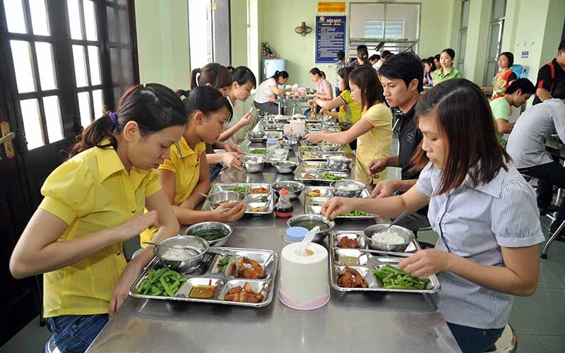 Bữa cơm giữa ca của công nhân Công ty TNHH Nam Dược (Khu công nghiệp Hòa Xá, tỉnh Nam Ðịnh). Ảnh: TRẦN KHÁNH