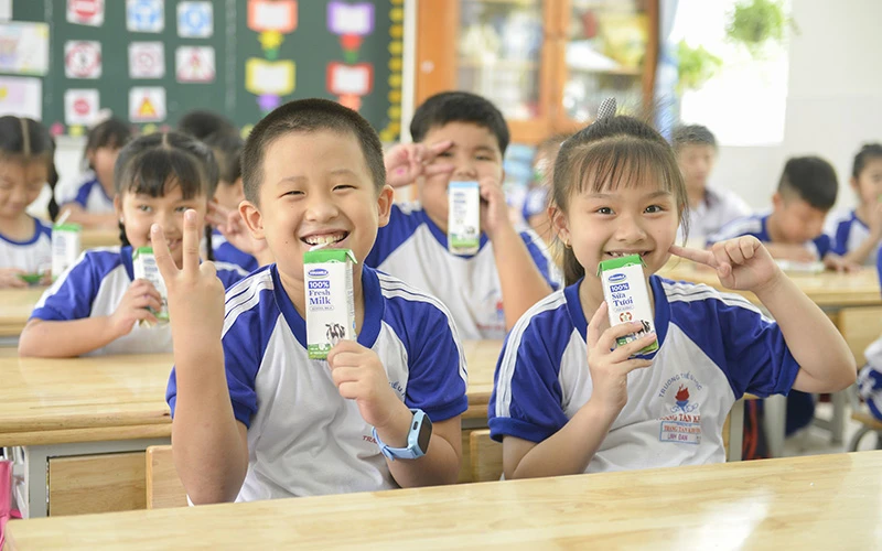 Các em học sinh trường Tiểu học Trang Tấn Khương, xã Long Thới, huyện Nhà Bè vui vẻ đón nhận những hộp sữa an toàn từ chương trình SHĐ.