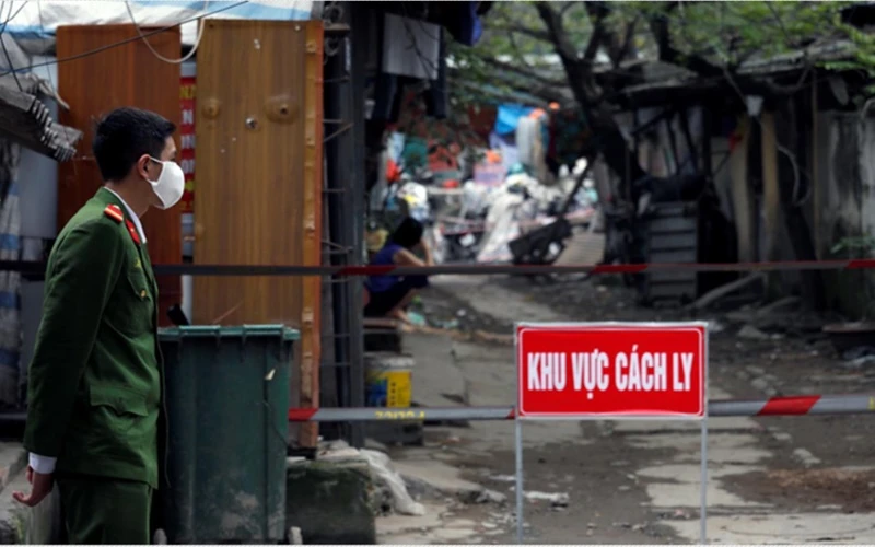 Cảnh sát đang canh gác gần nhà của người nhiễm virus SARS-CoV-2 tại một khu vực cách ly ở Hà Nội, Việt Nam, ngày 13-3-2020. (Ảnh: Reuters)