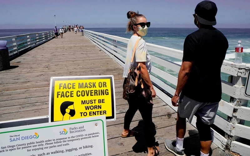Du khách đến bãi biển tại San Diego, California bắt buộc phải đeo khẩu trang. (Ảnh: Getty Images)