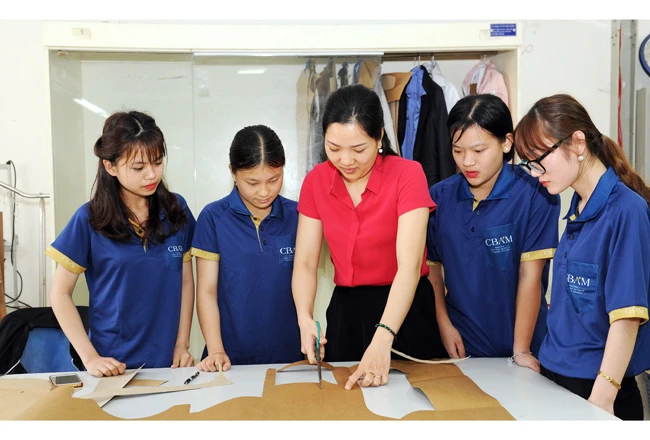 Giáo viên Trường cao đẳng nghề Kỹ thuật - Mỹ nghệ Việt Nam (huyện Gia Lâm, TP Hà Nội) hướng dẫn nghề may cho học viên. Ảnh: ĐẶNG MINH