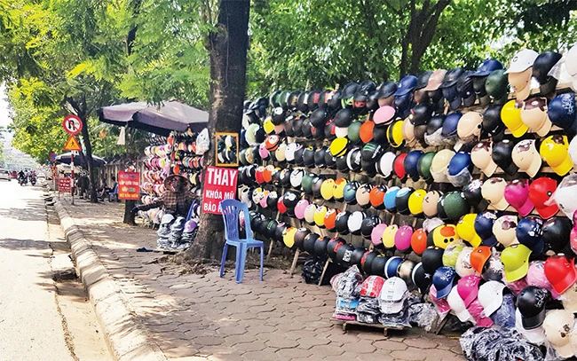 Mũ bảo hiểm không đạt chuẩn vẫn bày bán tràn lan từ nhiều năm nay tại phố Chùa Bộc (Hà Nội). Ảnh: MẠNH TRƯỜNG