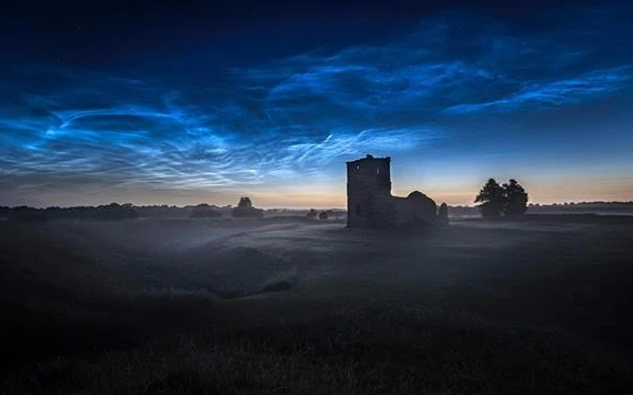 Những đám mây dạ quang được chụp trên Nhà thờ Knowlton ở Dorset, Vương quốc Anh, bởi nhà thiên văn học Ollie Taylor vào rạng sáng ngày 22-6. Ảnh: Ollie Taylor.