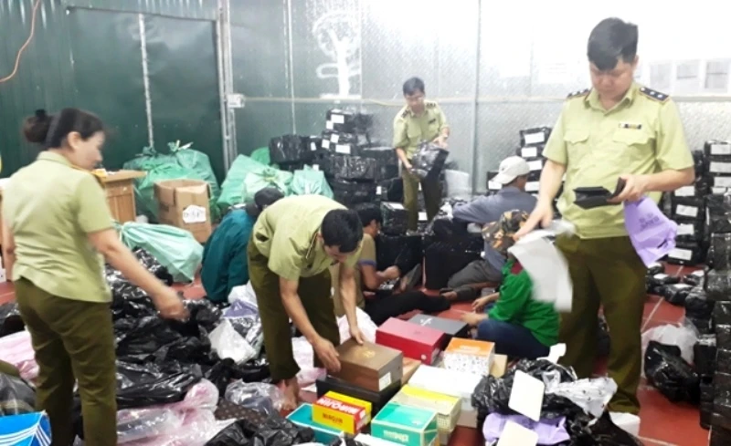 Lực lượng chức năng tiến hành kiểm đếm, phân loại, đóng gói hàng hóa tại kho hàng lậu ở số 145, đường Hoàng Diệu, TP Lào Cai.