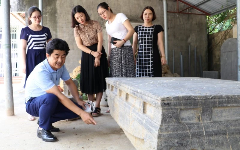 Cán bộ Bảo tàng Ninh Bình nghiên cứu họa tiết, hoa văn trên sập đá cổ, phát hiện ở xã Xích Thổ, huyện Nho Quan (Ninh Bình).