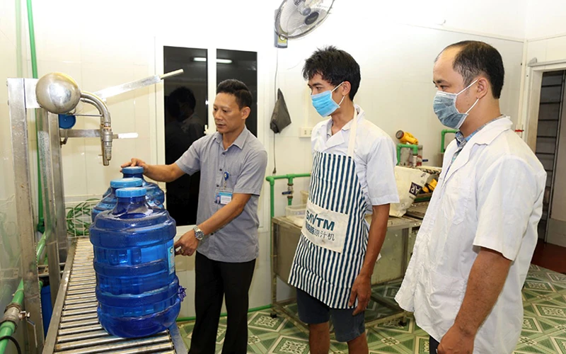 Ðoàn công tác của Chi cục An toàn vệ sinh thực phẩm tỉnh Ninh Bình kiểm tra một cơ sở sản xuất nước đóng chai tại huyện Hoa Lư. Ảnh: Minh Quang