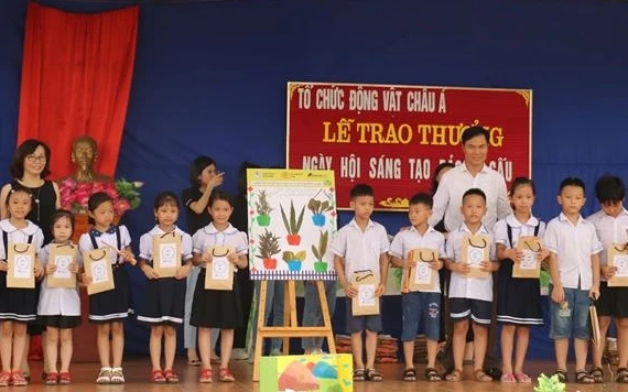 Đại diện Phòng giáo dục huyện Phúc Thọ và Tổ chức Động vật Châu Á cùng trao giải nhì cho một tổ dự thi.