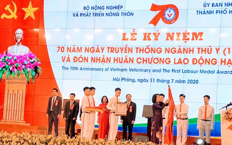 Phó Chủ tịch nước Đặng Thị Ngọc Thịnh gắn Huân chương Lao động hạng Nhất lên cờ truyền thống của ngành thú y Việt Nam.