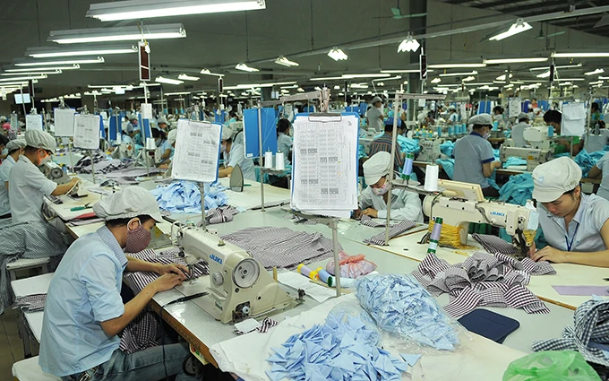 Ngành dệt may chịu tác động của dịch Covid-19 khiến nhiều lao động bị mất việc làm. Trong ảnh: Công nhân làm việc trong một xưởng may ở TP Đồng Hới (Quảng Bình). 