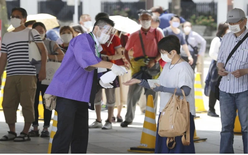 Khán giả được khử trùng tay trước khi vào đấu trường Ryogoku Kokugikan tại Tokyo, Nhật Bản, ngày 19-7. (Ảnh: Kyodo News)