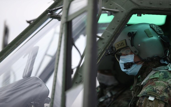 Phi công của quân đội quốc gia Colombia đeo khẩu trang khi điều khiển trực thăng trong thời điểm dịch Covid-19 bùng phát tại Bogota, ngày 7-4. (Ảnh: Reuters)