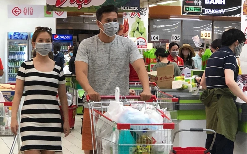 Người dân đeo khẩu trang khi đi mua sắm tại siêu thị vào tháng 3-2020. (Ảnh: T. Xuân)