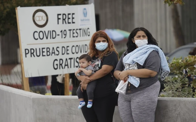 Hai phụ nữ cùng một trẻ em đang đợi làm xét nghiệm Covid-19 tại khu vực xét nghiệm lưu động của Đại học Y học và Khoa học Charles Drew (Los Angeles, Mỹ), ngày 22-7. (Ảnh: Reuters)