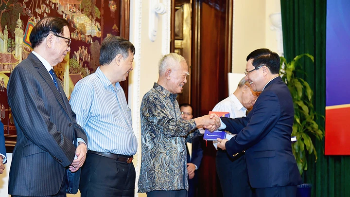 Phó Thủ tướng Phạm Bình Minh (phải) trao tặng sách cho các đại biểu tham dự Lễ ra mắt.