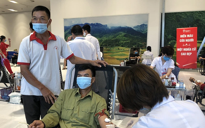 Ông Lê Trung Truyền (áo trắng) cùng anh họ tại buổi hiến máu sáng nay. 