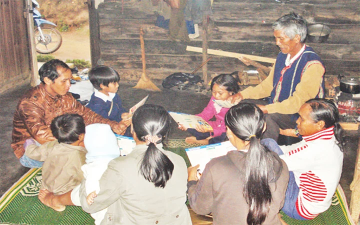 Già làng dân tộc Cơ Ho ở huyện Lạc Dương (Lâm Đồng) nói chuyện với con cháu về kế hoạch hóa gia đình.