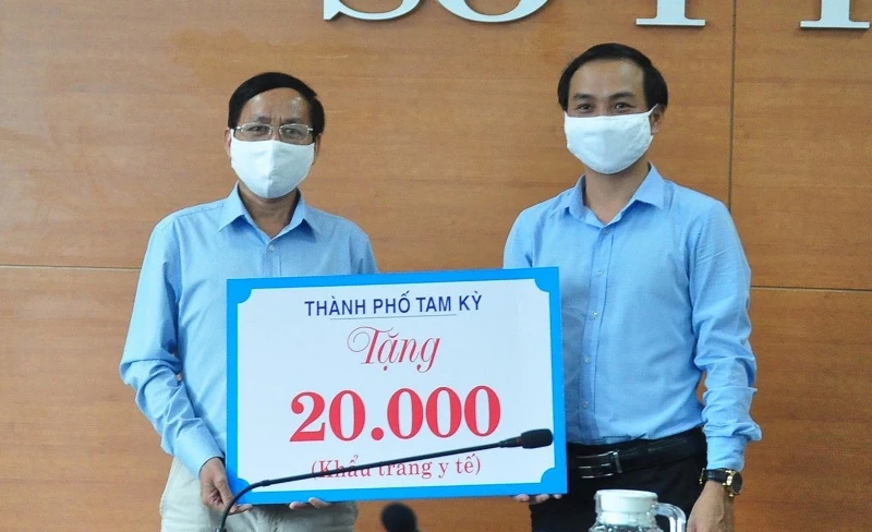 Phó Chủ tịch UBND TP Tam Kỳ Nguyễn Hồng Lai (bên phải) trao biểu trưng 20 nghìn khẩu trang cho Sở Y tế. 