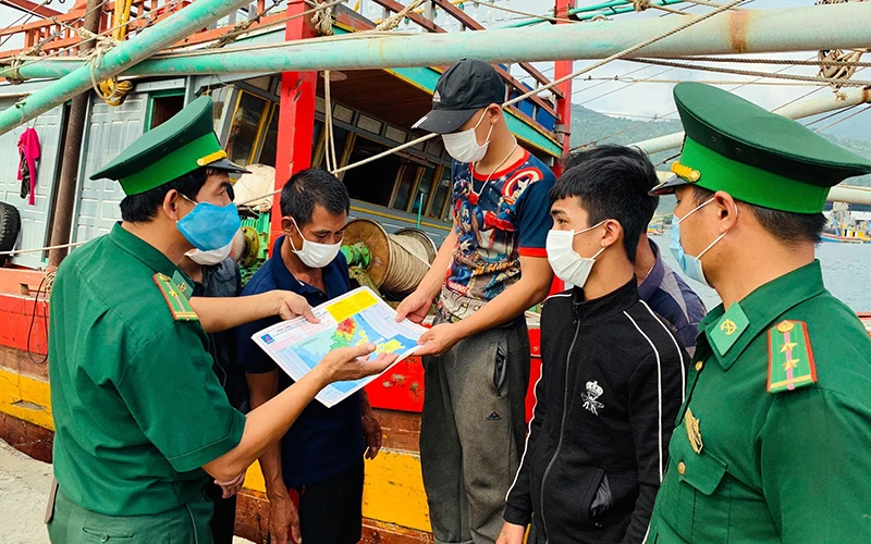 Bộ đội Biên phòng TP Ðà Nẵng tuyên truyền cho các ngư dân phòng, chống dịch Covid-19. Ảnh: BÁ VĨNH