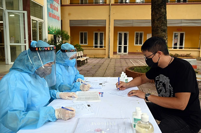 Người dân khai báo y tế tại điểm lấy mẫu xét nghiệm PCR ở Trường THCS Nguyễn Trãi (Ba Đình, Hà Nội). 