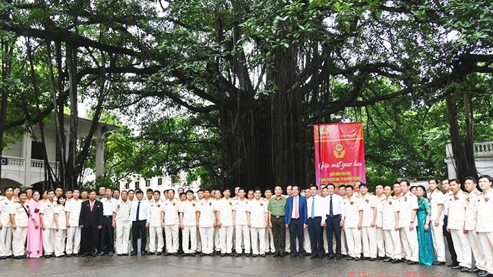 Các đại biểu dự chương trình chụp ảnh lưu niệm dưới gốc đa Báo Nhân Dân. Ảnh: nhandan.com.vn