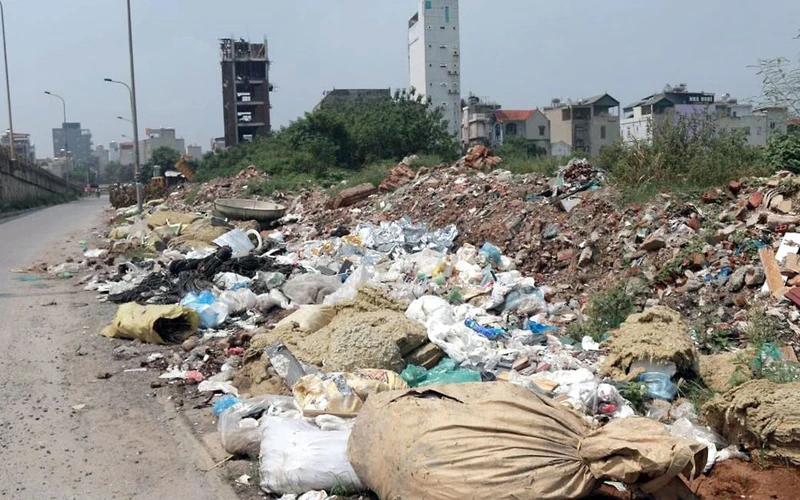 Rác thải sinh hoạt, rác vật liệu xây dựng vứt bừa bãi dọc tuyến đường qua đại lộ Thăng Long. Ảnh: DIỆU LINH