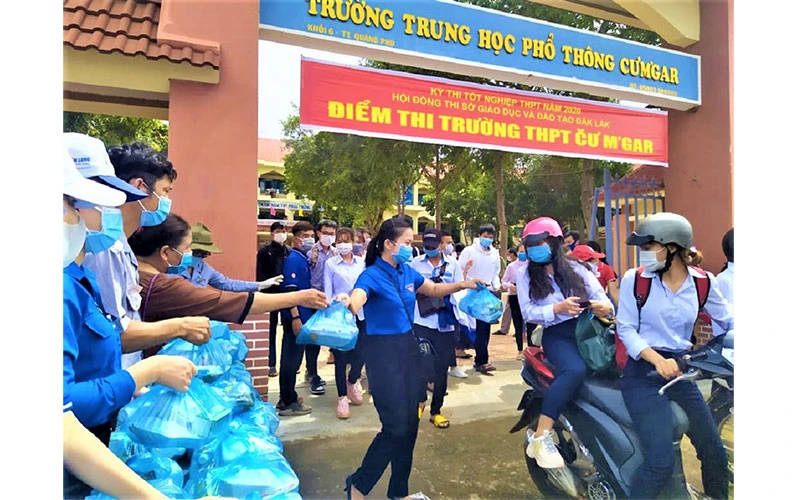 Đoàn viên, thanh niên tình nguyện ở điểm thi Trường THPT Cư M’gar (Đắk Lắk) phát hàng trăm suất cơm miễn phí cho các thí sinh và người nhà thí sinh. Ảnh: CÔNG LÝ
